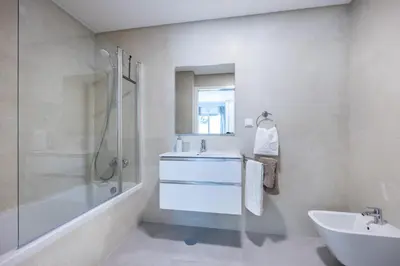 a white bathroom with a sink and a shower at Casa Salty in Albufeira
