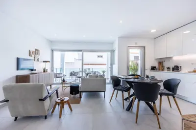 a kitchen and living room with a table and chairs at Casa Salty in Albufeira