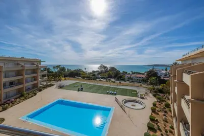 an apartment with a swimming pool and a view of the ocean at Algarve Beach Apartments in Albufeira