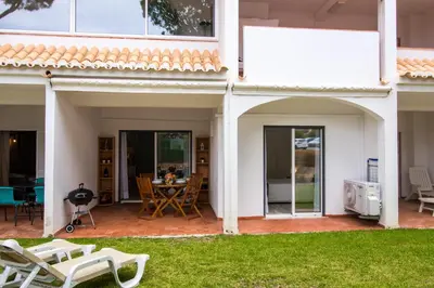 a white house with a patio and lawn at Açoteias B3 in Albufeira
