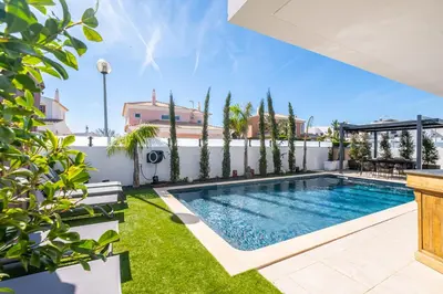 a swimming pool in the backyard of a house at Villa kambolé in Albufeira
