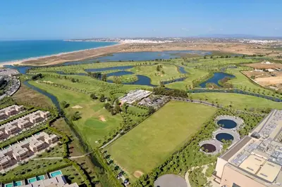 an aerial view of a golf course next to the ocean at Villa kambolé in Albufeira