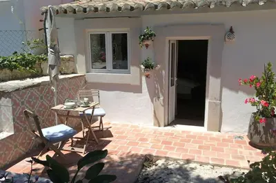 a patio with a table and a chair in front of a house at Vila Lobo Algarve in Faro