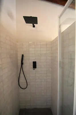 a bathroom with a shower with a shower head and a light at Vila Lobo Algarve in Faro
