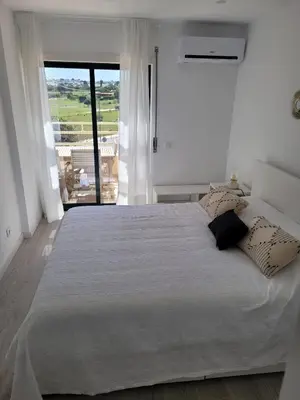 a bedroom with a large white bed with pillows on it at Apartamento T1 Salgados in Guia