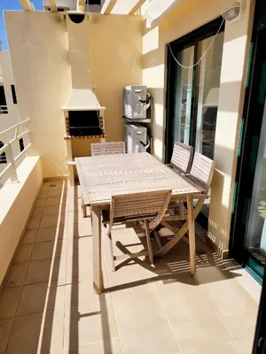 a wooden table and chairs on a balcony at Apartamento T1 Salgados in Guia