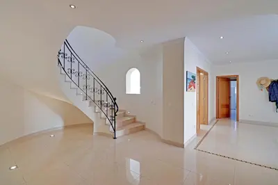 a white hallway with a staircase in a house at Casa do Pomar by Portucasa in Alte