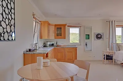 a kitchen with a table and a dining room at Casa do Pomar by Portucasa in Alte