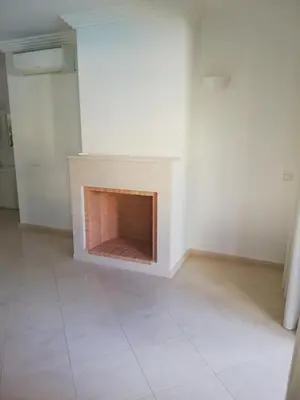 a white room with a fireplace in the middle of it at Villa V2 U in Olhos de Água