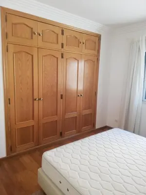 a bedroom with wooden cabinets and a white mattress at Villa V2 U in Olhos de Água