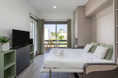 a bedroom with a bed and a tv and a balcony at Centralgarve - Elegant and Cosy Studio in the Heart of Vilamoura - Aldeia do Mar T0 in Vilamoura