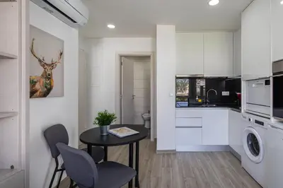 a kitchen and dining room with a table and chairs at Centralgarve - Elegant and Cosy Studio in the Heart of Vilamoura - Aldeia do Mar T0 in Vilamoura