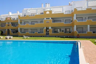 an apartment with a swimming pool in front of a building at Vilamoura Apartment Jacaranda - By Dalma Portuguesa in Vilamoura