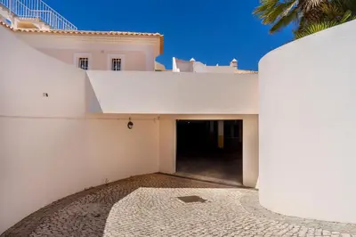 a white building with a tunnel in the middle at Apartamento no Condomínio Baia Village com Piscina in Albufeira
