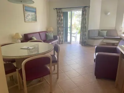 a living room with a table and chairs and a couch at Lovely 2 Bedroom Home inside a Resort in Albufeira in Albufeira