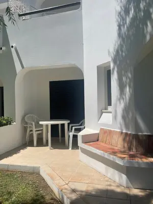 a patio with a table and chairs and a bench at Lovely 2 Bedroom Home inside a Resort in Albufeira in Albufeira