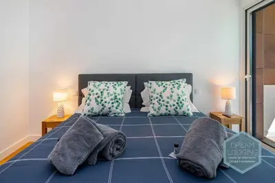 a bed with pillows and a cat laying on it at Albufeira Prime 1B - Dream Lodging in Albufeira