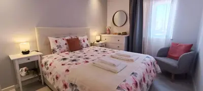 a white bedroom with a bed and a chair at 209 Modern Apartment in central Albufeira close to everything in Albufeira