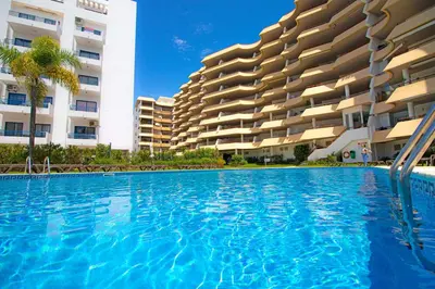 a swimming pool in front of a building at Apartamento Varandas do Sol in Vilamoura