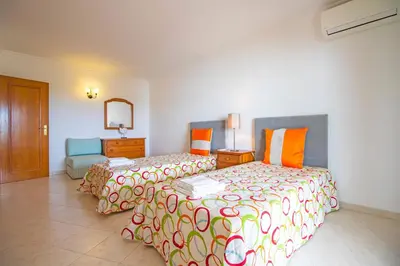 a hotel room with two beds and a mirror at Apartamento Varandas do Sol in Vilamoura