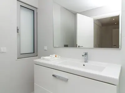 a white bathroom with a sink and a mirror at Harmony 4I House by Stay ici Algarve Holiday Rental in Albufeira