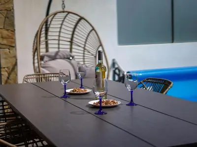 a table with a bottle of wine and three wine glasses at Harmony 4I House by Stay ici Algarve Holiday Rental in Albufeira