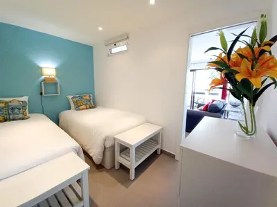 a bedroom with a large bed with pink and yellow pillows at T2 Tenis Golf Mar in Vilamoura
