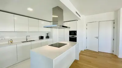 a white kitchen with white cabinets and a counter top at Prime by Check-in Portugal in Albufeira