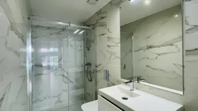 a white bathroom with a shower and a sink at Prime by Check-in Portugal in Albufeira