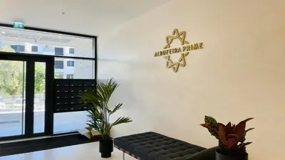 a living room with a couch and a sign on the wall at Prime by Check-in Portugal in Albufeira