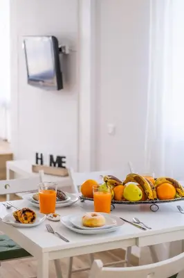 a white kitchen with a white table and chairs at #011 T1 Libertos by Home Holidays in Albufeira