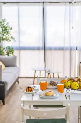 a table with two plates of food and orange juice at #011 T1 Libertos by Home Holidays in Albufeira