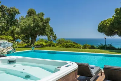 a swimming pool with a jacuzzi tub and chairs at Vila Santa Eulália in Albufeira