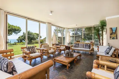 a living room with a lot of furniture and large windows at Vila Santa Eulália in Albufeira