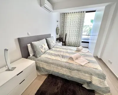 a bedroom with a large bed and a window at Beachside Apartment - With Pool by HD PROPERTIES in Quarteira