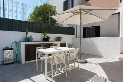 a white table and chairs with an umbrella on a patio at NUZZA - Vilamoura Marina with BBQ in Vilamoura