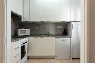 a kitchen with white cabinets and a white refrigerator at NUZZA - Vilamoura Marina with BBQ in Vilamoura