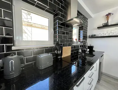 a black and white kitchen with a sink and a window at Nancy Apartment - Near Vilamoura Marina by HD PROP in Vilamoura