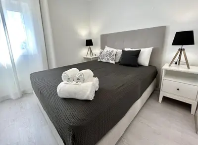 a bedroom with a large bed with towels on it at Nancy Apartment - Near Vilamoura Marina by HD PROP in Vilamoura
