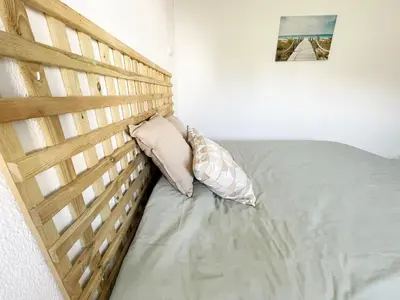 a bed with a wooden headboard in a bedroom at Panoramic Seaview - 2 Bedroom, Main Ave, 15 Min Walk Beach, Workspace in Albufeira