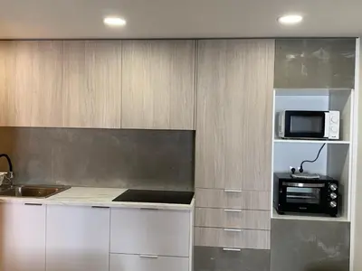 a kitchen with white cabinets and a microwave at CASA DAS CEGONHAS in Faro