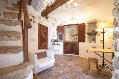 a living room with a white chair and a table at Quinta Molinum Ad Mare in Boliqueime