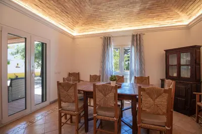 a dining room with a wooden table and chairs at Quinta Molinum Ad Mare in Boliqueime
