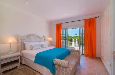 a bedroom with a large bed and a balcony at Oceans 8. in Almancil