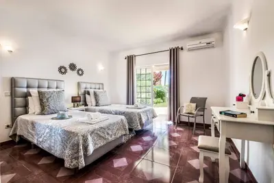a hotel room with two beds and a desk at Casa Palmeira in Terras Novas
