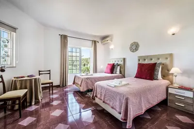 a bedroom with two beds and a table and chairs at Casa Palmeira in Terras Novas