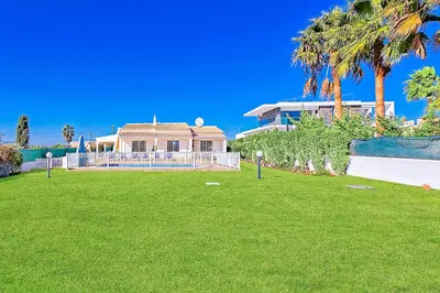 a large house with palm trees and a yard at Casa Palmeira in Terras Novas
