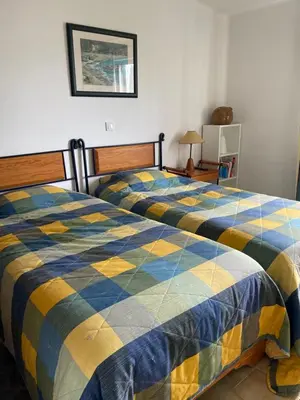 a bedroom with two beds with blue and yellow at FeWo Cesar Manrique - Albufeira, Portugal in Albufeira