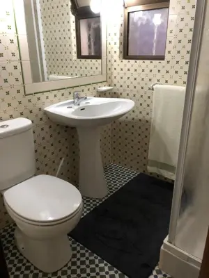 a bathroom with a white toilet and a sink at FeWo Cesar Manrique - Albufeira, Portugal in Albufeira