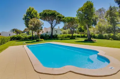 a swimming pool in a yard with trees at AL - Barracuda Village in Vilamoura